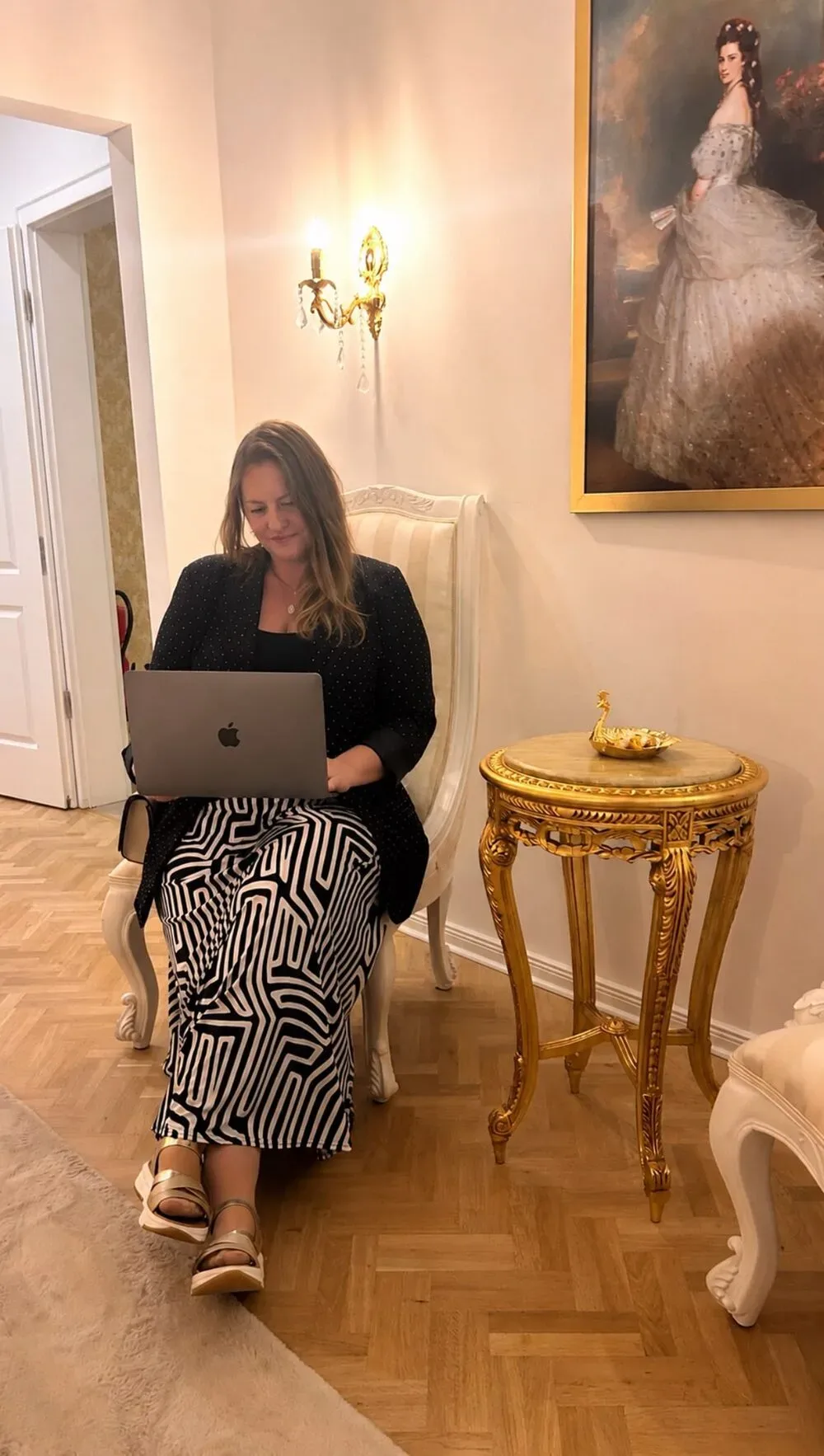 Melanie Dorn arbeitet am Laptop in einem elegant eingerichteten Raum